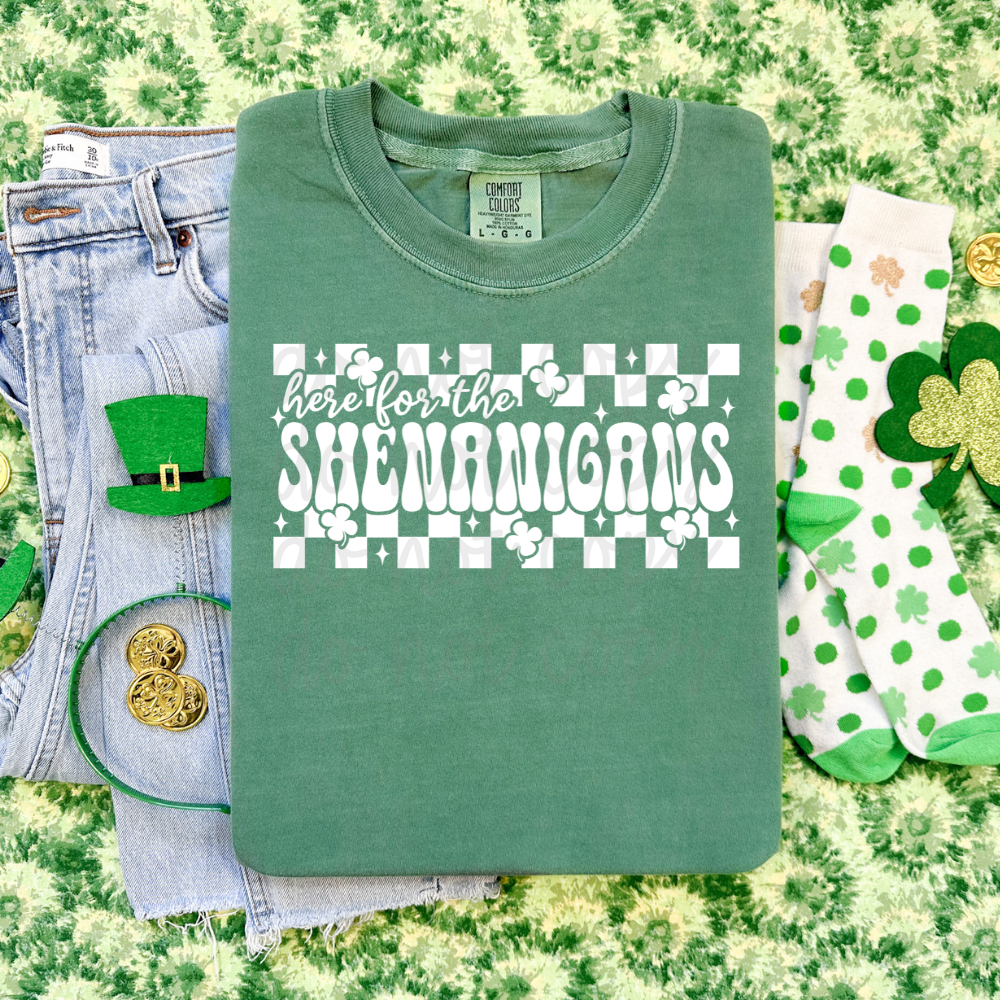Here for the Shenanigans St. Patrick’s Day graphic tee with white retro lettering and checkerboard shamrock design on green Comfort Colors shirt.