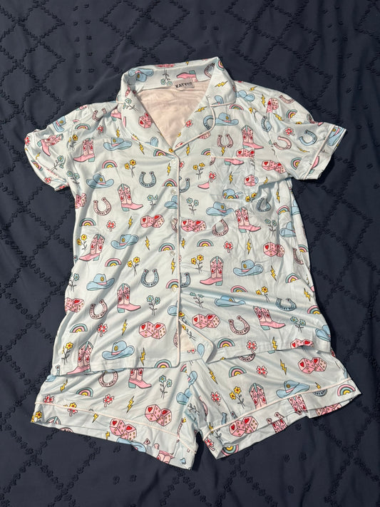 Women's pajama set with cowgirl pattern on a dark quilted surface