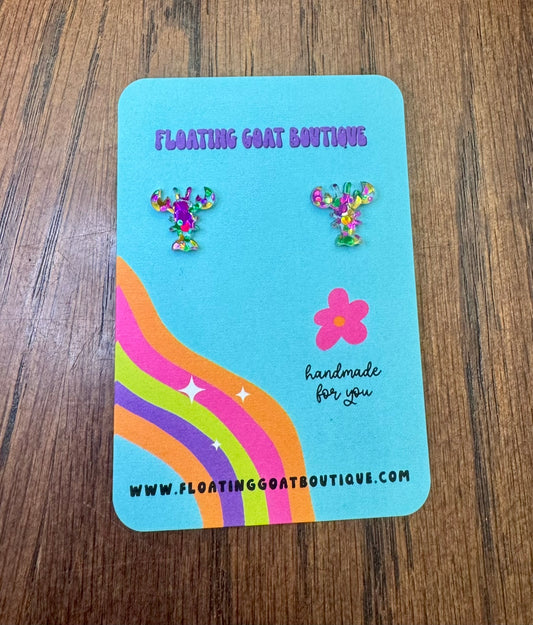 Earring card with Crawfish Mardi Gras Confetti earrings and 'Floating Goat Boutique' branding on a wooden surface.
